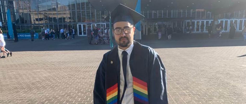 Parsa Dara in a cap and gown with a rainbow academic stole.