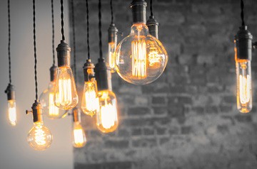 Close-up on hanging vintage-style light fixtures supplying warm light