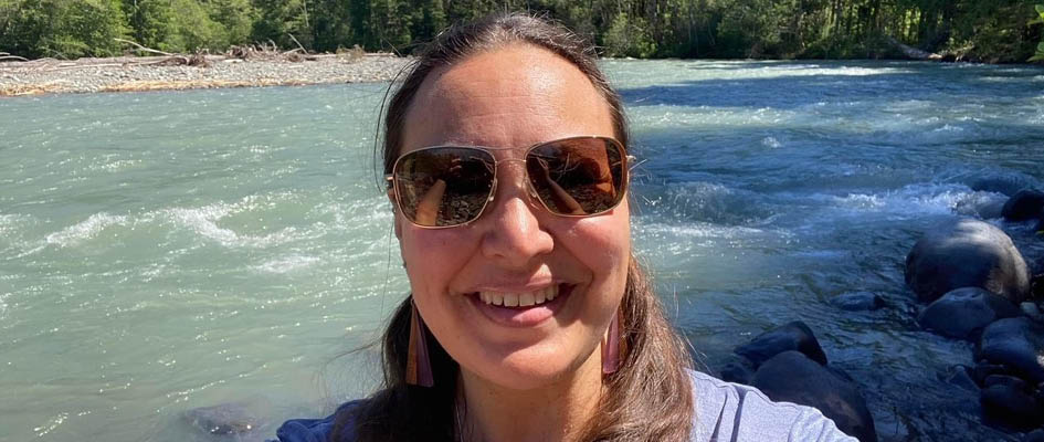 Tasha Repp in sunglasses taking a selfie by a river