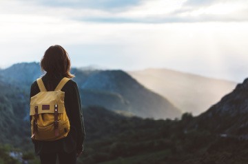 Person wearing backpack looking off into the mountains