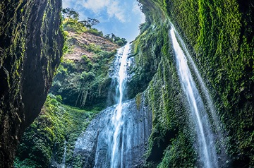 Looking up to the top of a waterfall on a sunny day