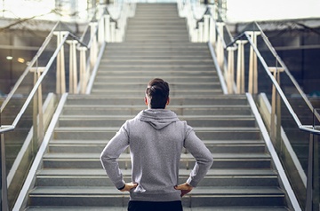 Man looking up steep flight of stairs