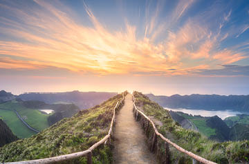 Walking path surrounded by lake and sky