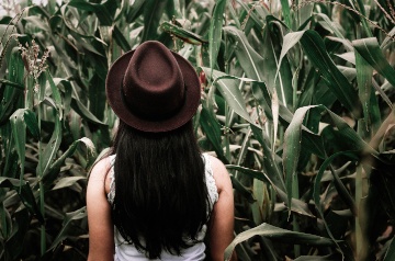 Woman in a hat in corn field