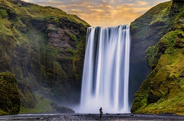 Person standing in front of waterfall