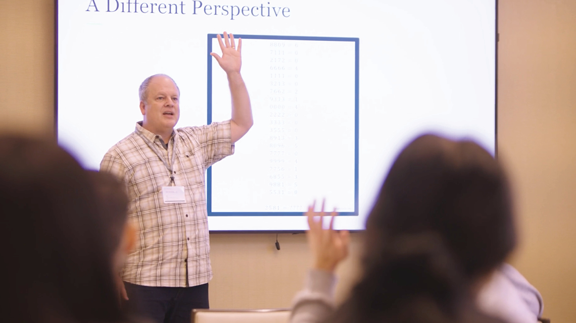 Presenter speaking in front of projector screen