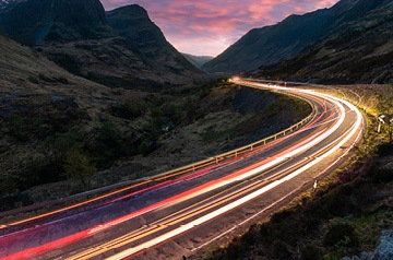 Blurred traffic lights on highway at dusk