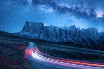 Time lapse photo of highway lights in front of a mountain range