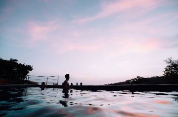 Person in infinity pool at dusk